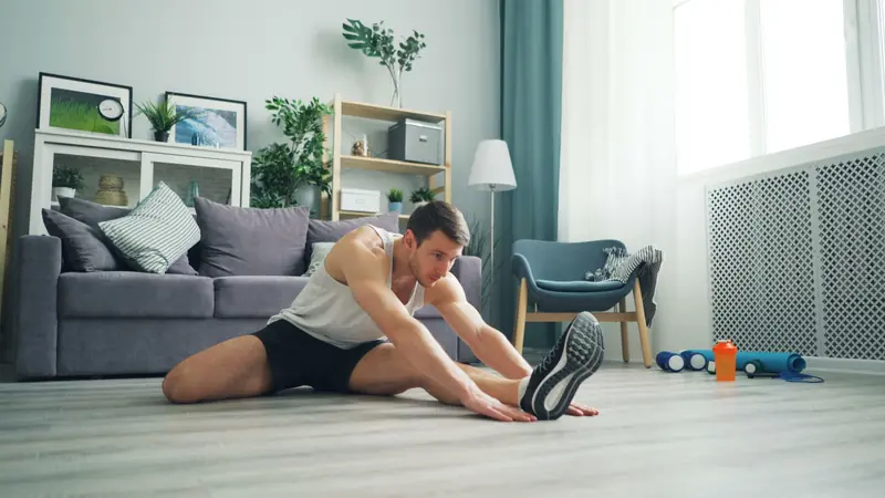 Young man stretching at home in a modern living room setting