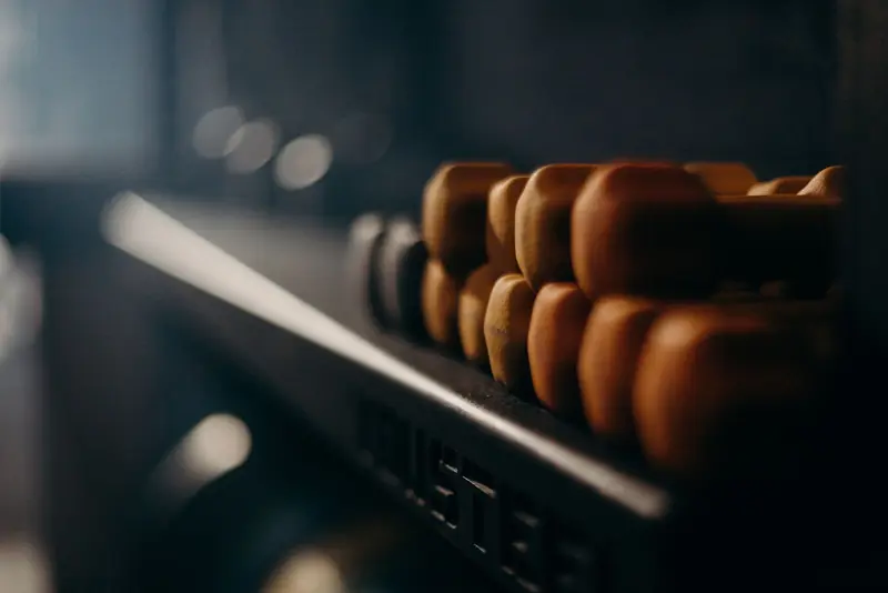 A rack of dumbbells in a dimly lit gym, highlighting fitness equipment