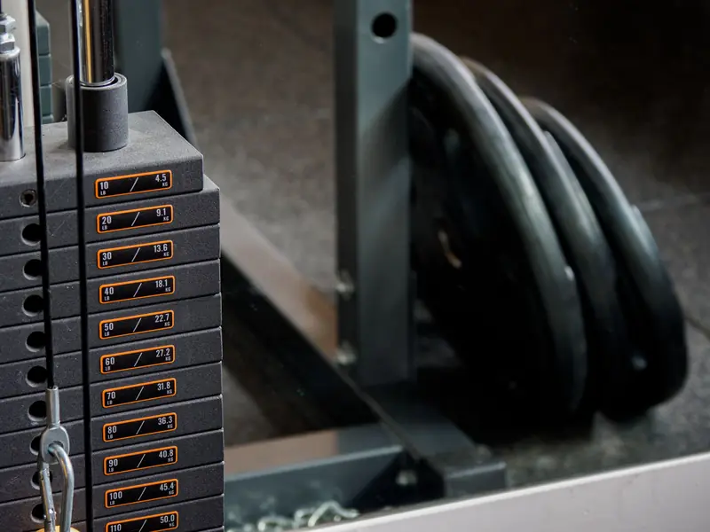 Detailed view of a gym machine's weight stack and weight plates, ideal for fitness-themed visuals